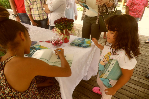 Crianças autografam cartilha ambiental ilustrada por elas, na Bahia Marina